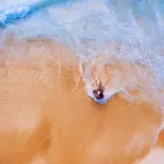 Uomo in Spiaggia bagnato dal Mare