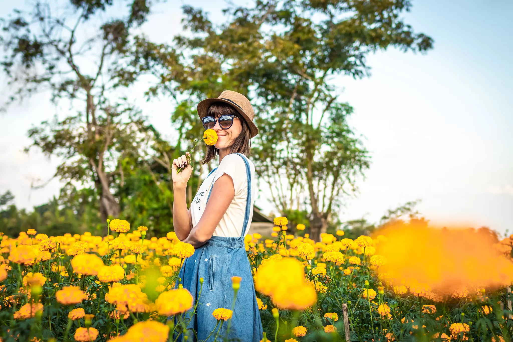 Ragazza che Annusa un Fiore in un Campo