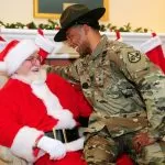 Militare seduto sulle gambe di Babbo Natale