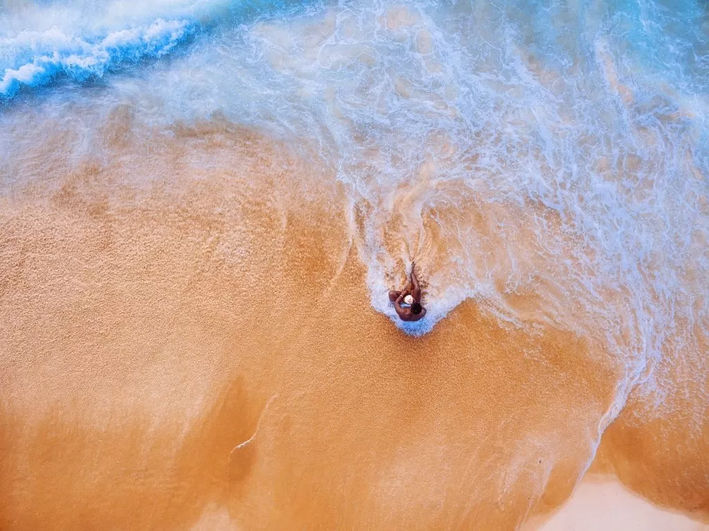 Uomo in Spiaggia bagnato dal Mare