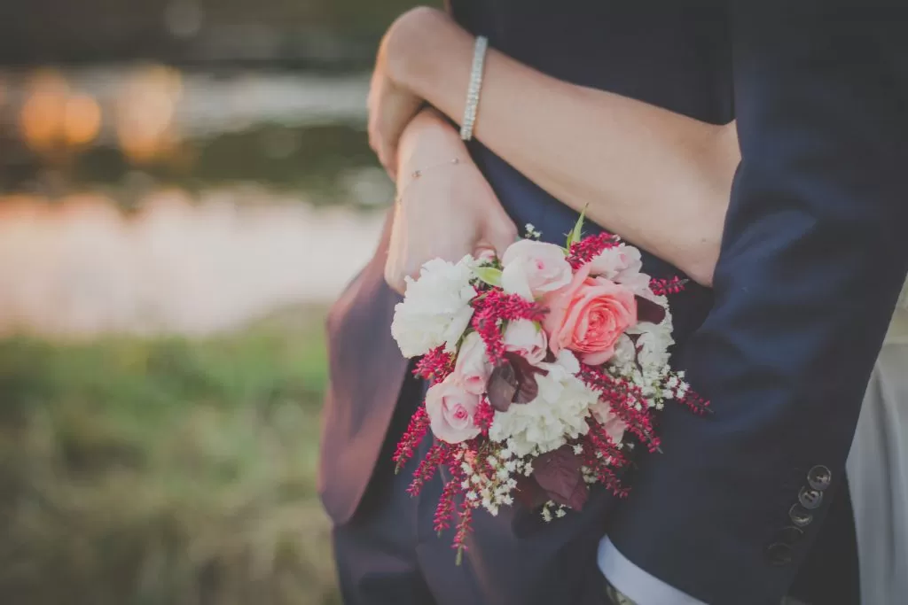 Sposa con Bouquet che abbraccia lo Sposo